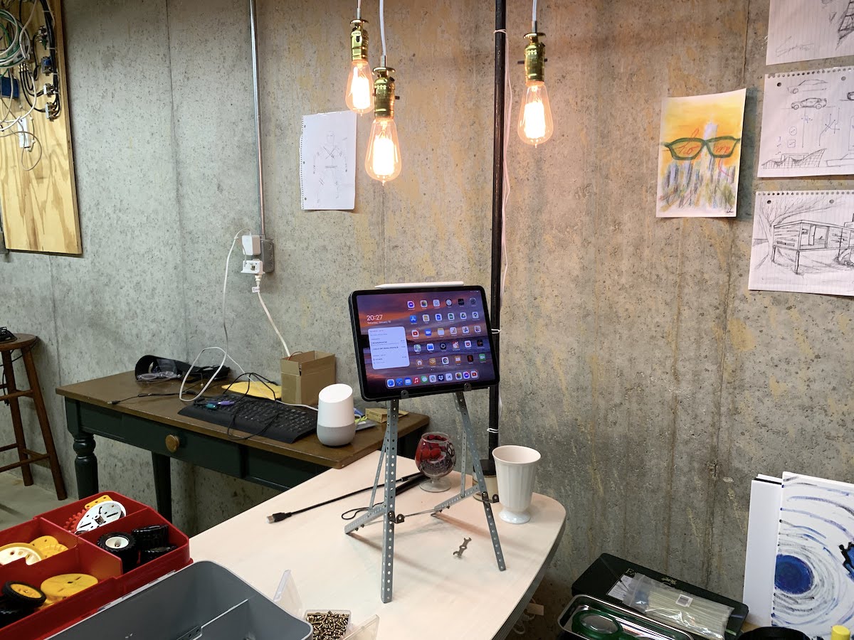 A half-finished basement with tools and lights surrounding a desk